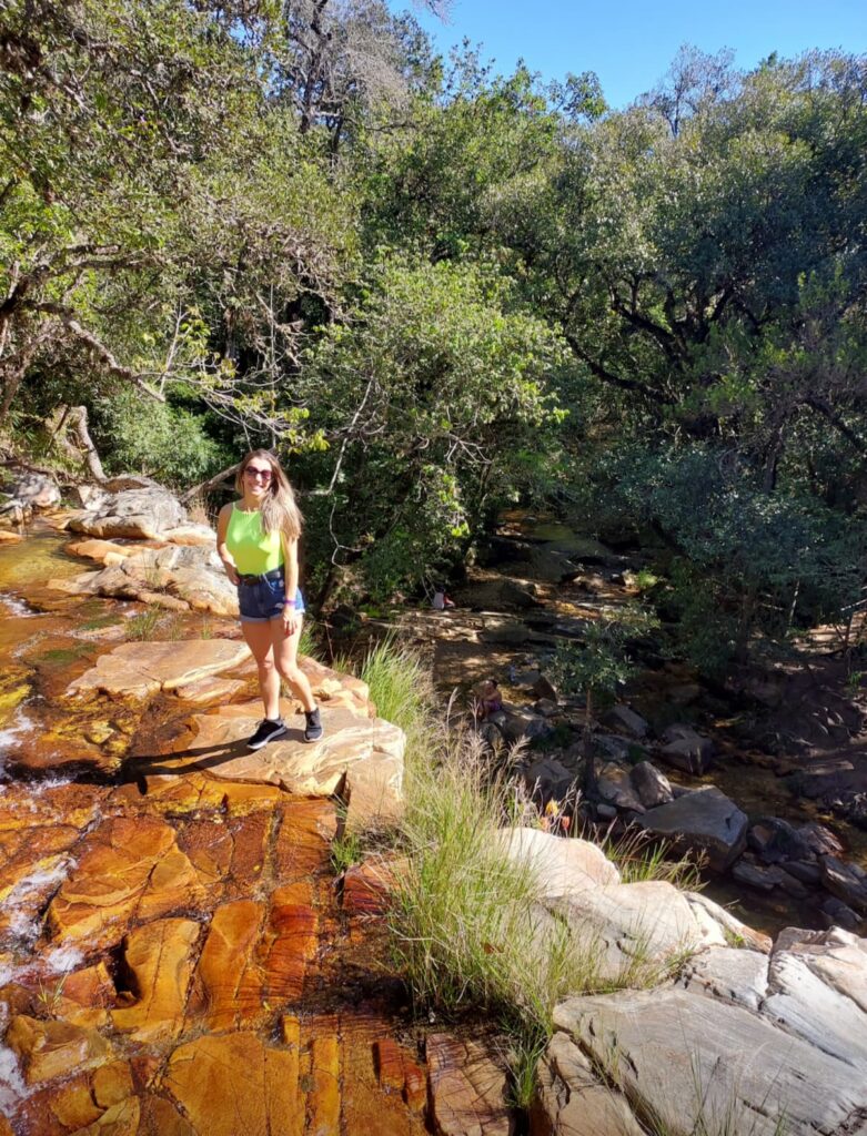 Imagem mostra turista na cachoeira Vale das Borboletas em São Thomé das Letras, um das melhores cachoeiras de Minas Gerais.