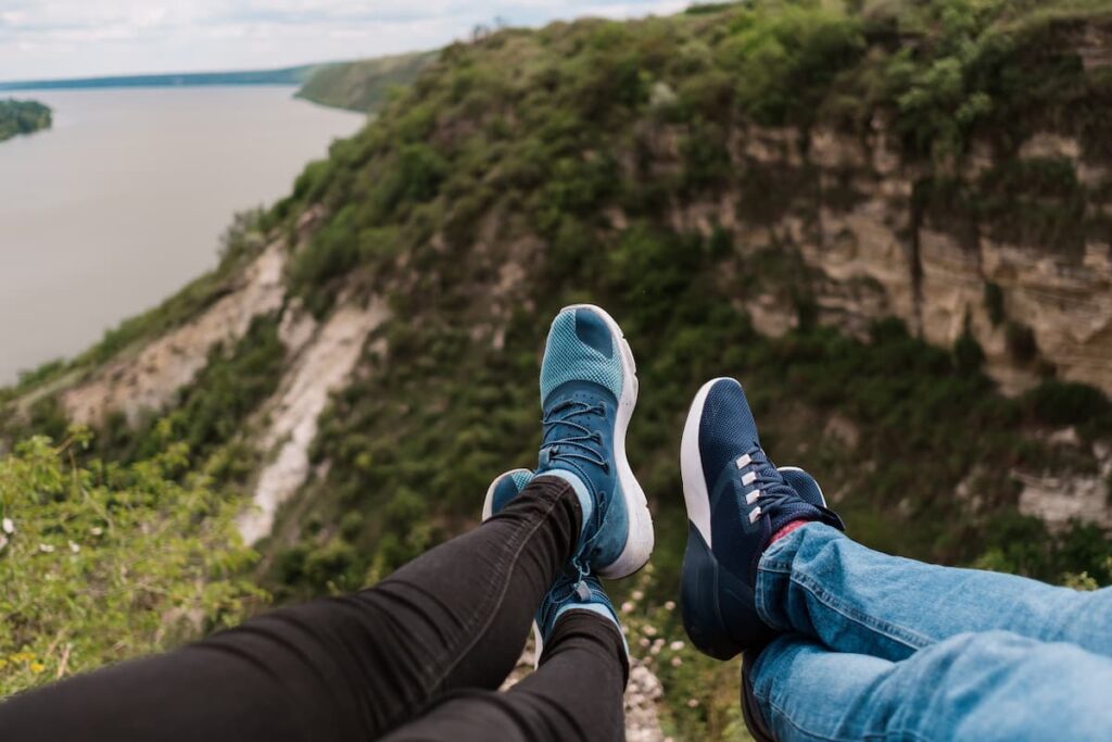 Imagem mostra casal descansando e apreciando uma bela paisagem.