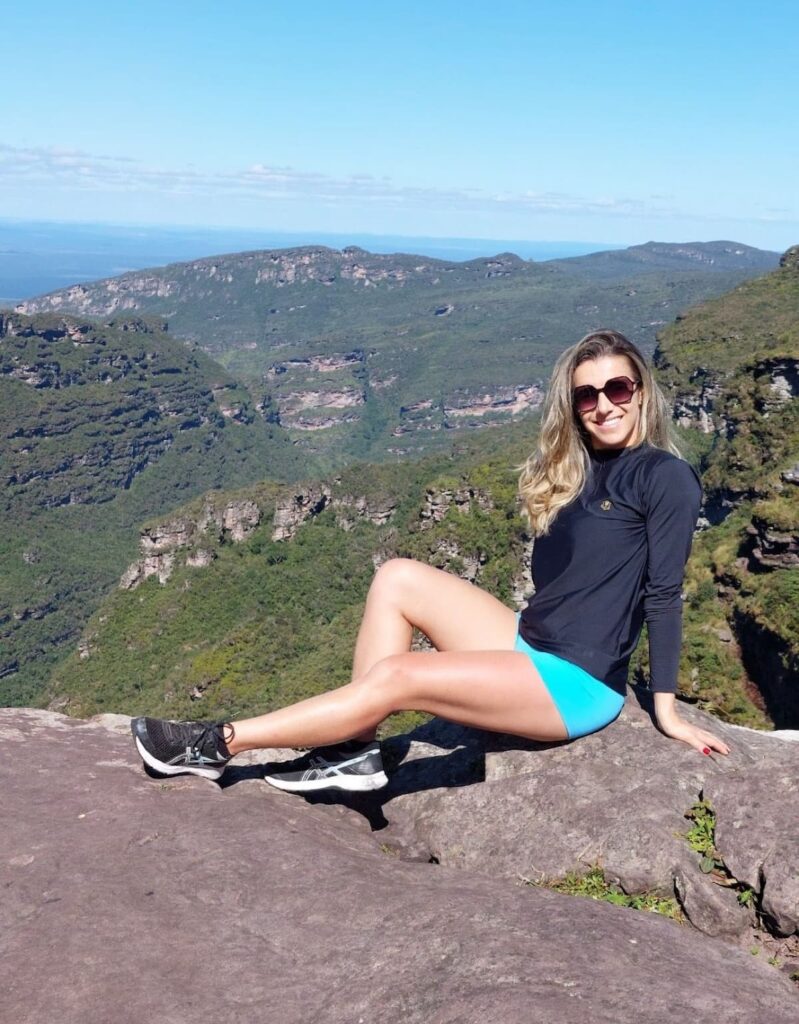 Imagem mostra turista no topo da Cachoeira da Fumaça, uma das cachoeiras mais altas do Brasil.