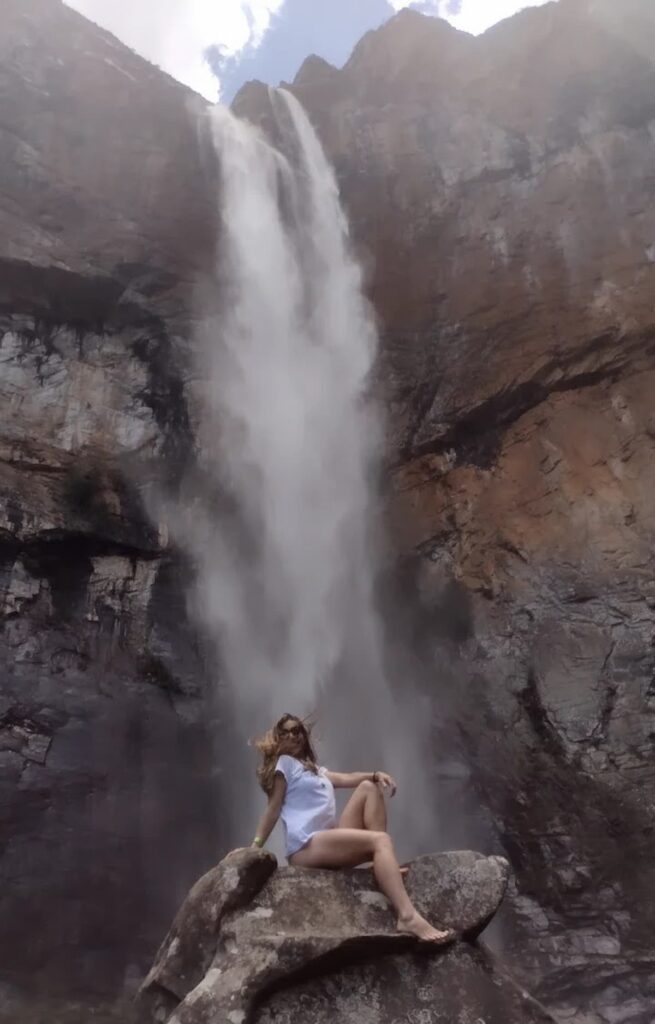 imagem mostra turista tirando foto frente a uma das 7 Maravilhas da Estrada Real