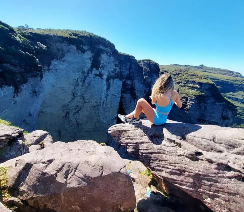Imagem mostra turista fotografando a magnífica Cachoeira da Fumaça na Chapada Diamantina.